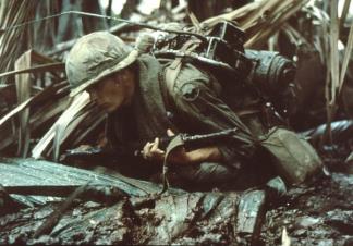 A Radio Telephone Operator (RTO) of the 9th Infantry Division takes evasive action whilst on an operation in the Mekong Delta.