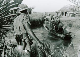 9th Infantry Division soldiers use a local sampan to cross a river near Long An in the Mekong Delta.