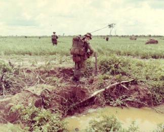 A heavily laden member of Co ‘B’, 2nd Royal Australian Regiment, crosses a ditch during a search and clear operation.