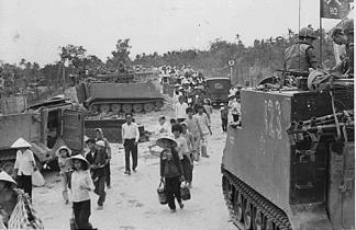 M-113 Armored Personnel Carriers of the 5th Battalion, 60th Infantry, 9th Infantry Division stand by as villagers evacuate My Tho in the Mekong Delta during the 1968 Tet Offensive.