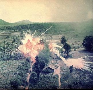 Napalm bombs explode on Viet Cong structures south of Saigon.