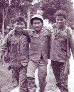 A wounded CIDG Strike Force member is helped to the medical aid station at Ap Suoi by his comrades after a fire fight with the Viet Cong in War Zone “D”.