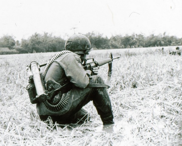 A rifleman of the 101st Airborne scans the tree line ahead while crossing an inundated area in January 1966.