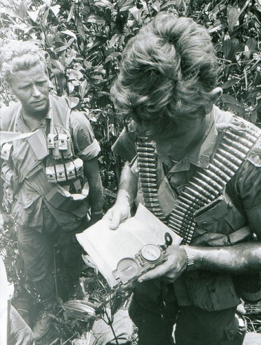 Soldiers of 1st Battalion, 506th Infantry, 101st Airborne Division use a Lensatic Compass to check their position.