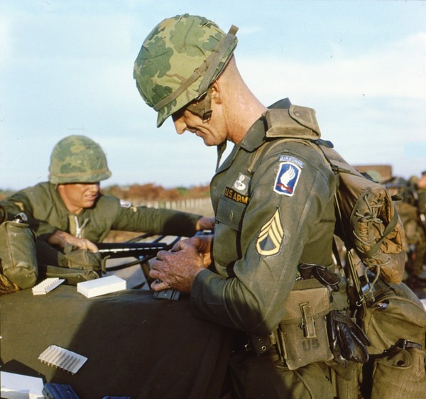 A Staff Sergeant of the 173rd Airborne loads his rifle magazine with brand new ammunition.
