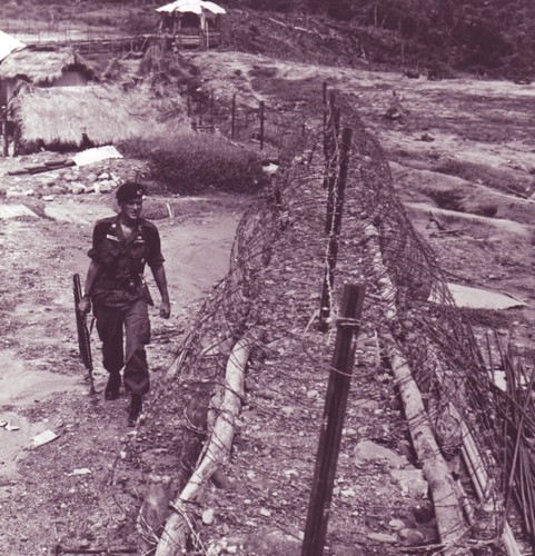 Special Forces Captain Roger Donlon inspects the perimeter of the CIDG Camp at Nam Dong, two months after the camp was attacked by the Viet Cong.
