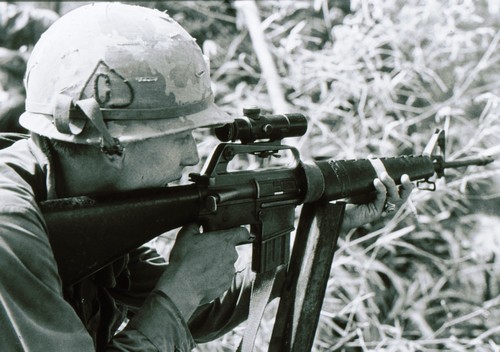 A member of Company C, 2nd Battalion, 35th Infantry, 25th Infantry Division takes aim with a scope attached to handle of his M16A1 rifle.