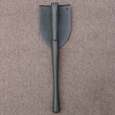 The shovel and pick blade folded along the wooden shaft for carrying.