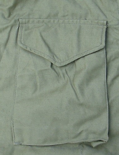 The pockets of the M1965 Field Coat featured V-cut flaps and were closed by snap fasteners.