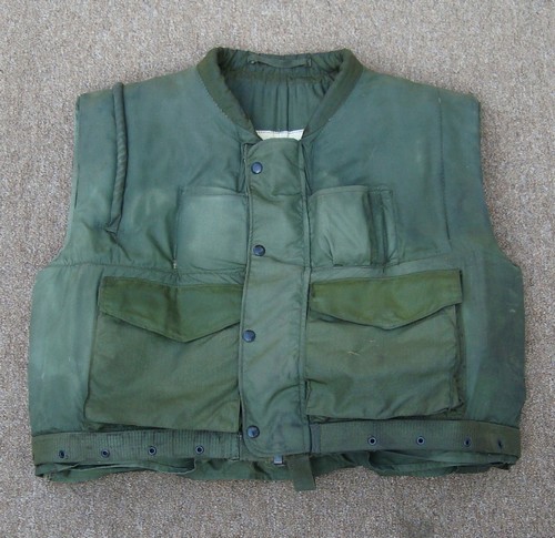 The 2nd version of the Marine Corps M1955 vest had a zip front closure, an integral cartridge belt holder, a rifle guard over the right shoulder and two lower cargo pockets.