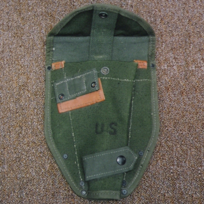 The M1956 Intrenching Tool Cover was made from OD7 cotton duck and featured leather reinforcements.