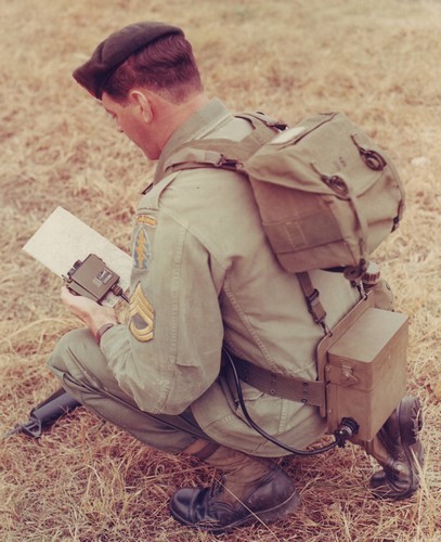 A Special Forces SFC uses field pack adapter straps to wear a butt pack on his back, thus allowing him to carry a position locator (Man Pack) on his belt and suspenders.