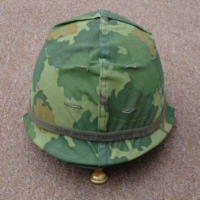 Mitchell pattern cover with camouflage band on an M1 steel helmet.