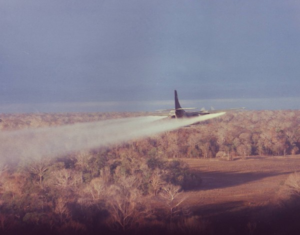 A C-123 sprays defoliant over the target area in South Vietnam during project Pink Rose.