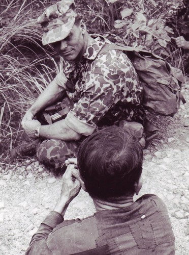 Special Forces Captain Edward Rybat looks at a Viet Cong suspect captured during mission in war zone “D”, north of Ben Cat (III Corps).