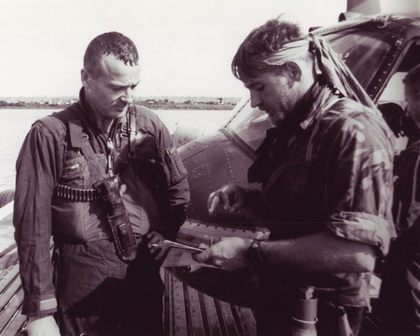 A SEAL team member confers with Lieutenant Commander Roland F.