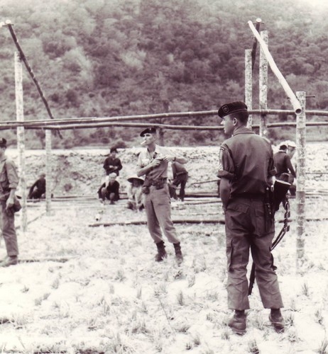 Members of the A-14 Team, 5th Special Forces Detachment, observe the construction of the CIDG camp at Chau Lang, An Giang province, Mekong Delta (IV Corps).