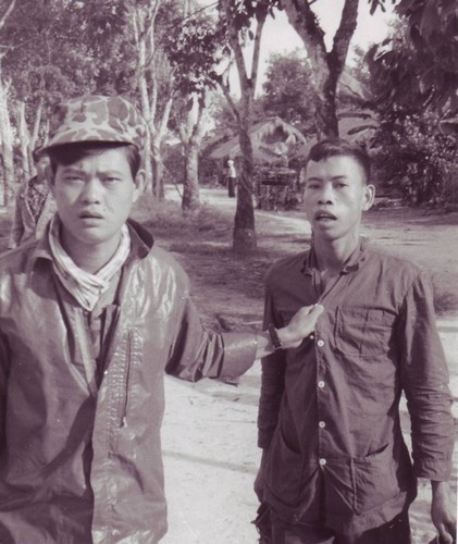 A CIDG Strike Force member leads a captured Viet Cong guerrilla after a firefight at Bau Bang hamlet in war zone “D”.