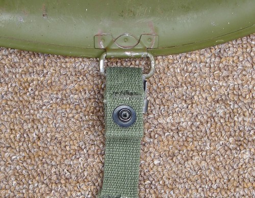 The M1 helmet was equipped with two hinged loops for attaching the two-piece webbing chinstrap.