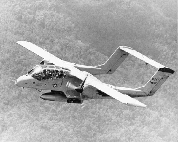 A USAF OV-10 Bronco with an external fuel tank (drop tank) and armed with marker rockets acts as a Forward Air Controller (FAC) in support of a SOG Recon Team.
